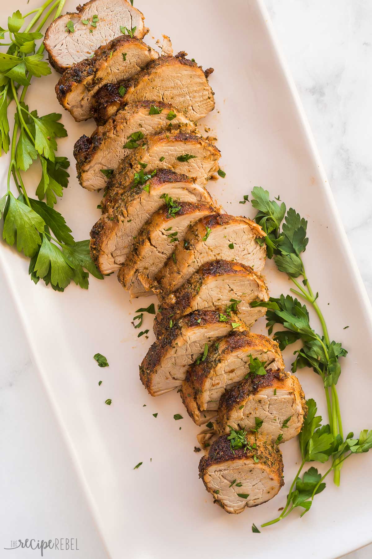 overhead image of air fryer tenderloin on platter with fresh parsley