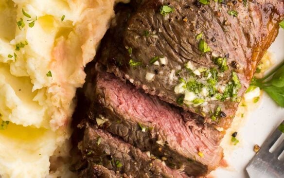 mashed potatoes on the side and sliced steak with garlic butter