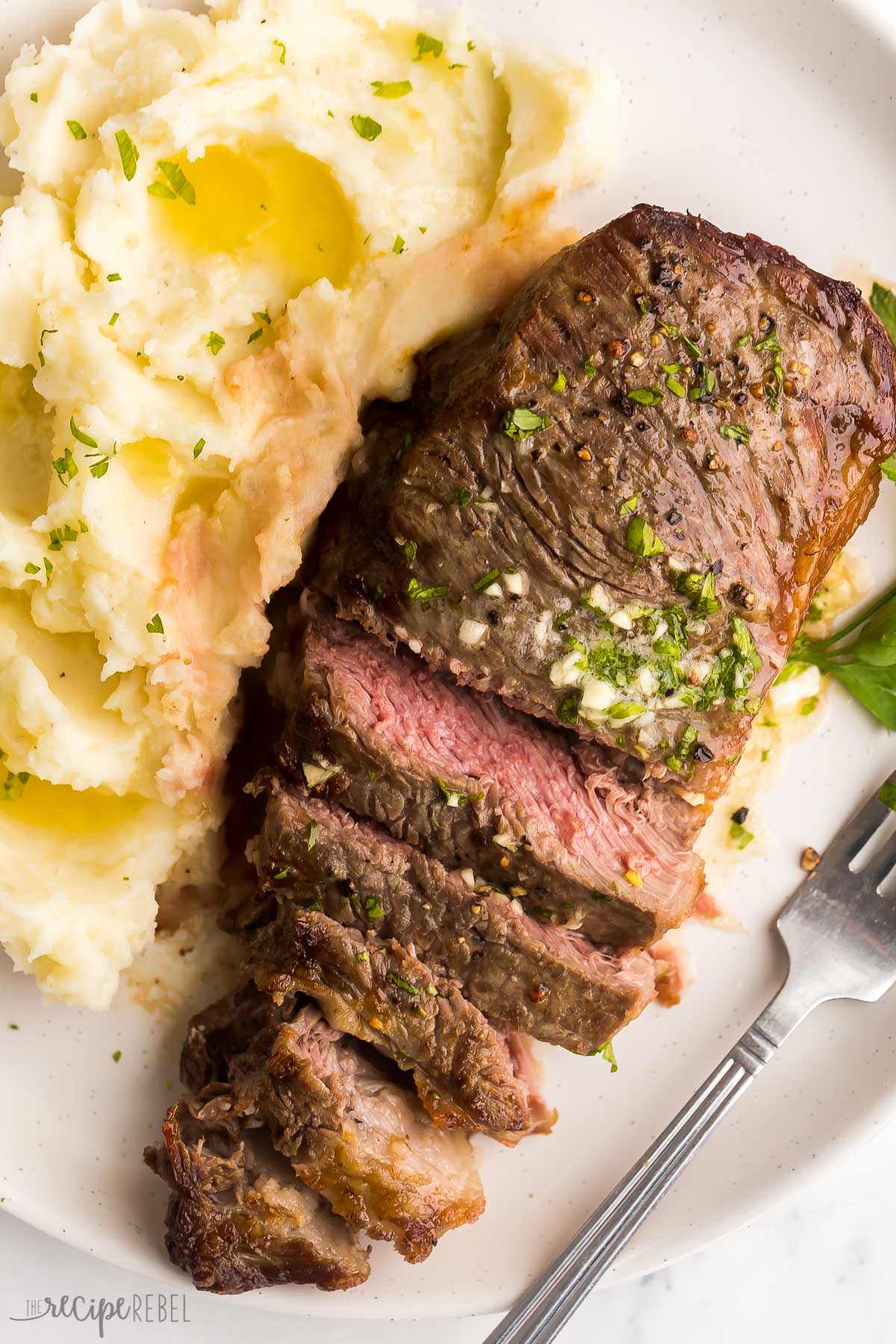 mashed potatoes on the side and sliced steak with garlic butter