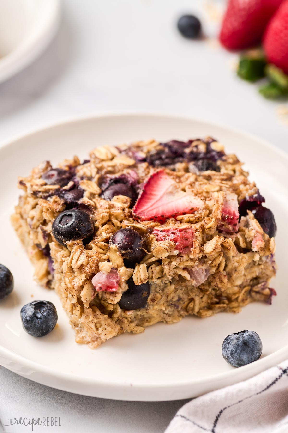 piece of baked oatmeal with blueberries and strawberries on plate