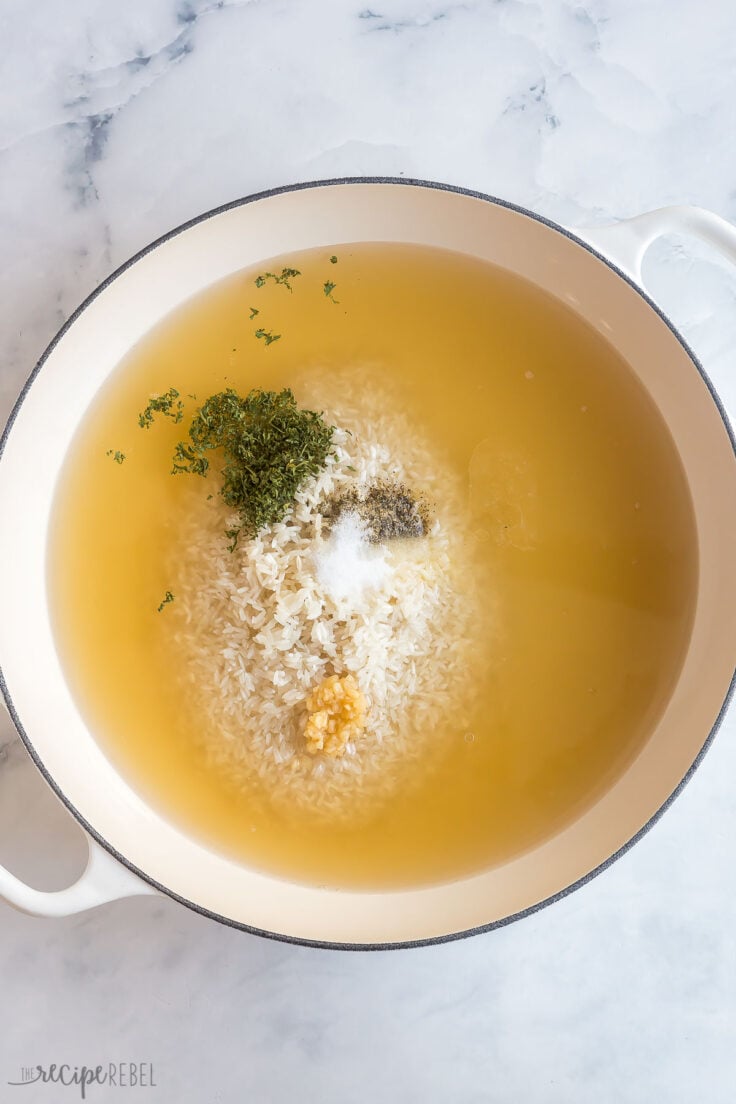 broth rice and seasonings in large white braiser