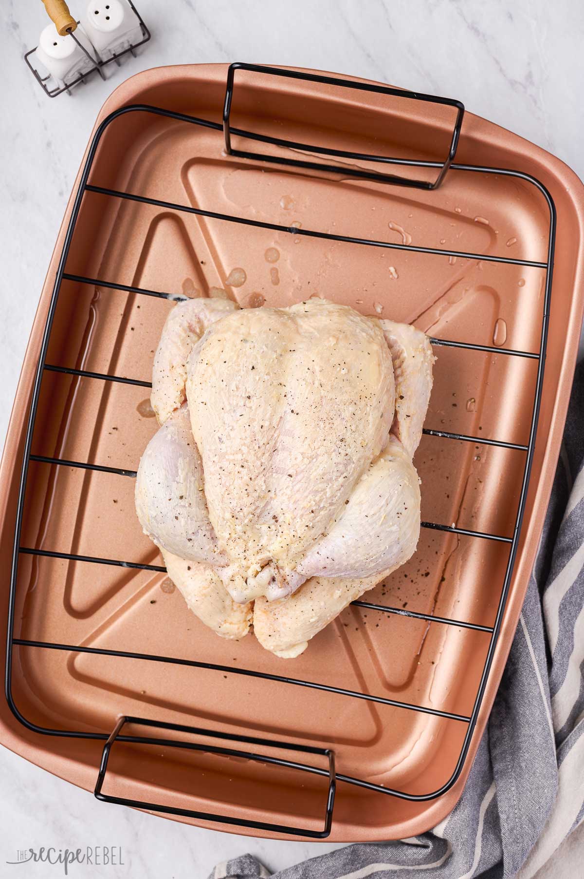 whole uncooked chicken on a roasting pan