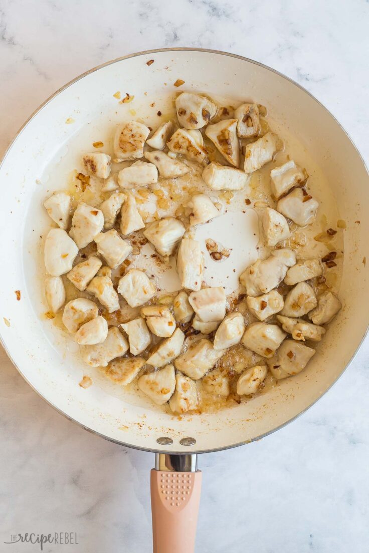 cubed chicken in white skillet cooked