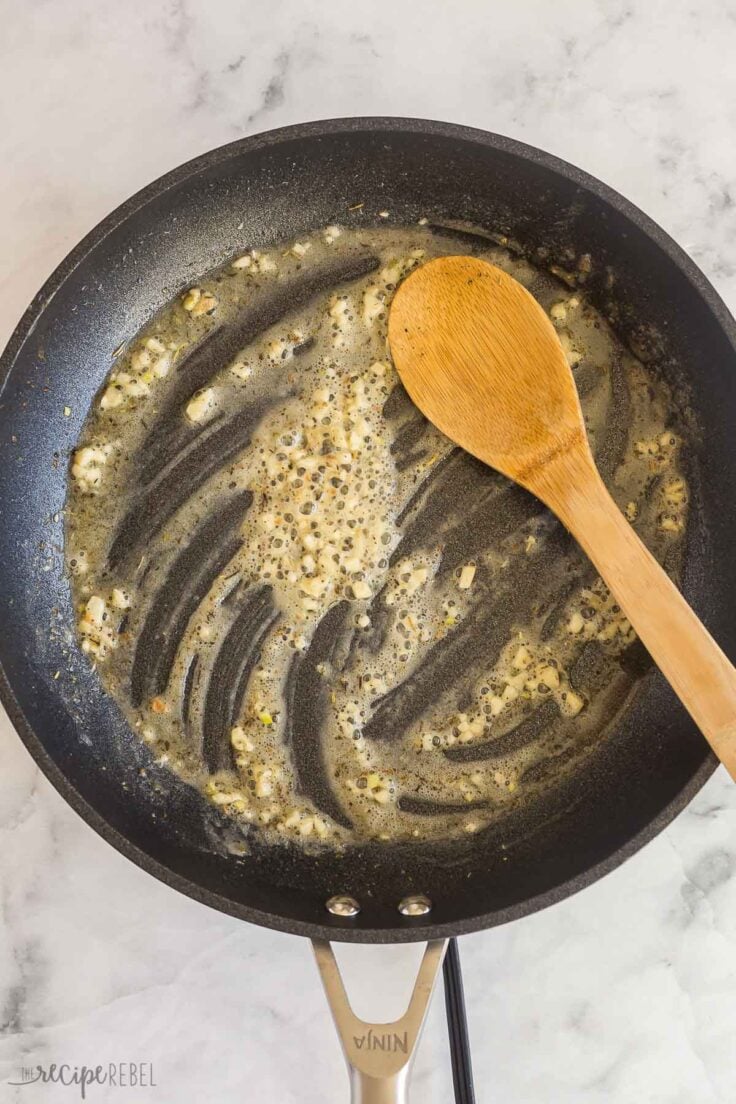 garlic cooking in butter in black skillet