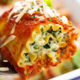 A lasagna roll up filled with ricotta cheese and tomato sauce.