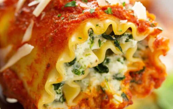 A lasagna roll up filled with ricotta cheese and tomato sauce.