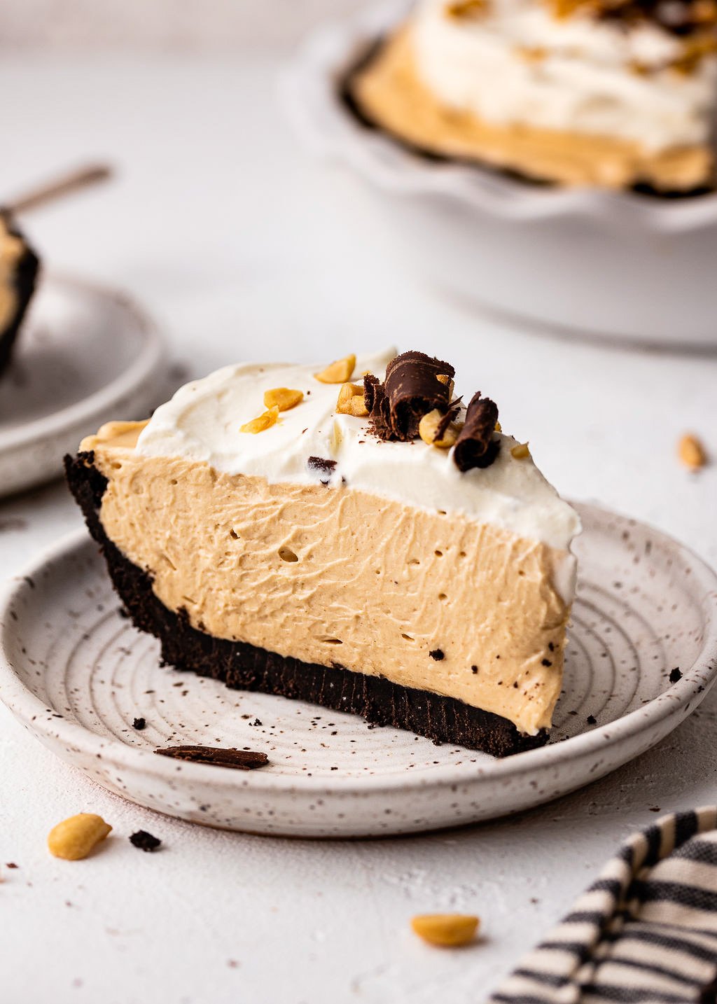 slice of peanut butter pie on grey plate with whipped cream.