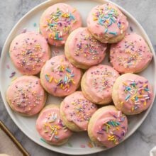 overhead image of frosted sugar cookies with pink frosting and sprinkles