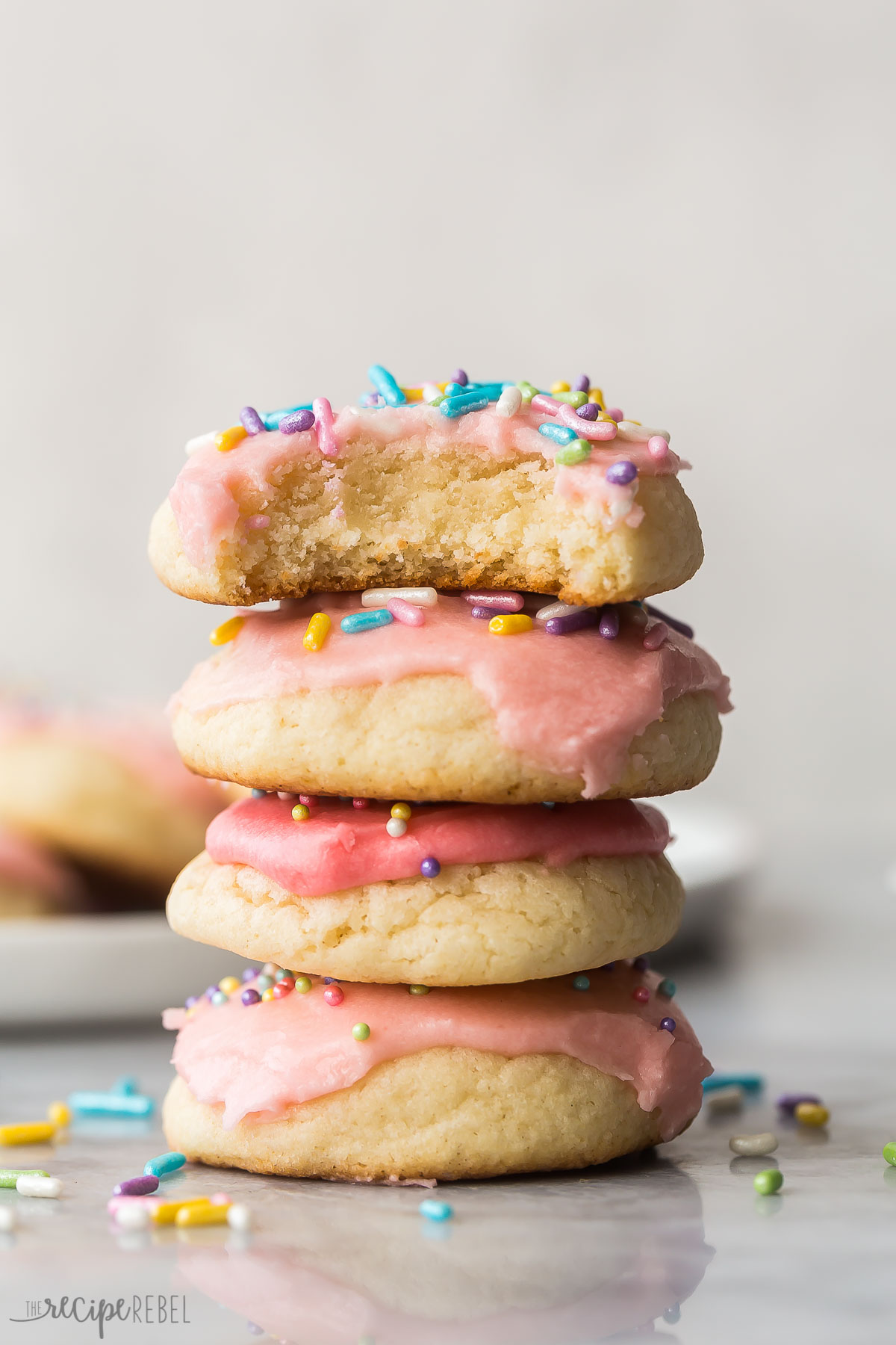 stack of four thick soft sugar cookies with frosting