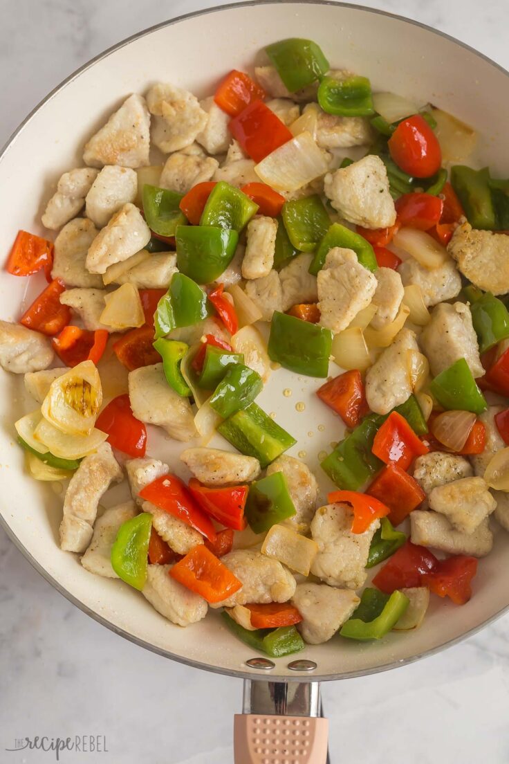 chicken pieces and peppers in skillet