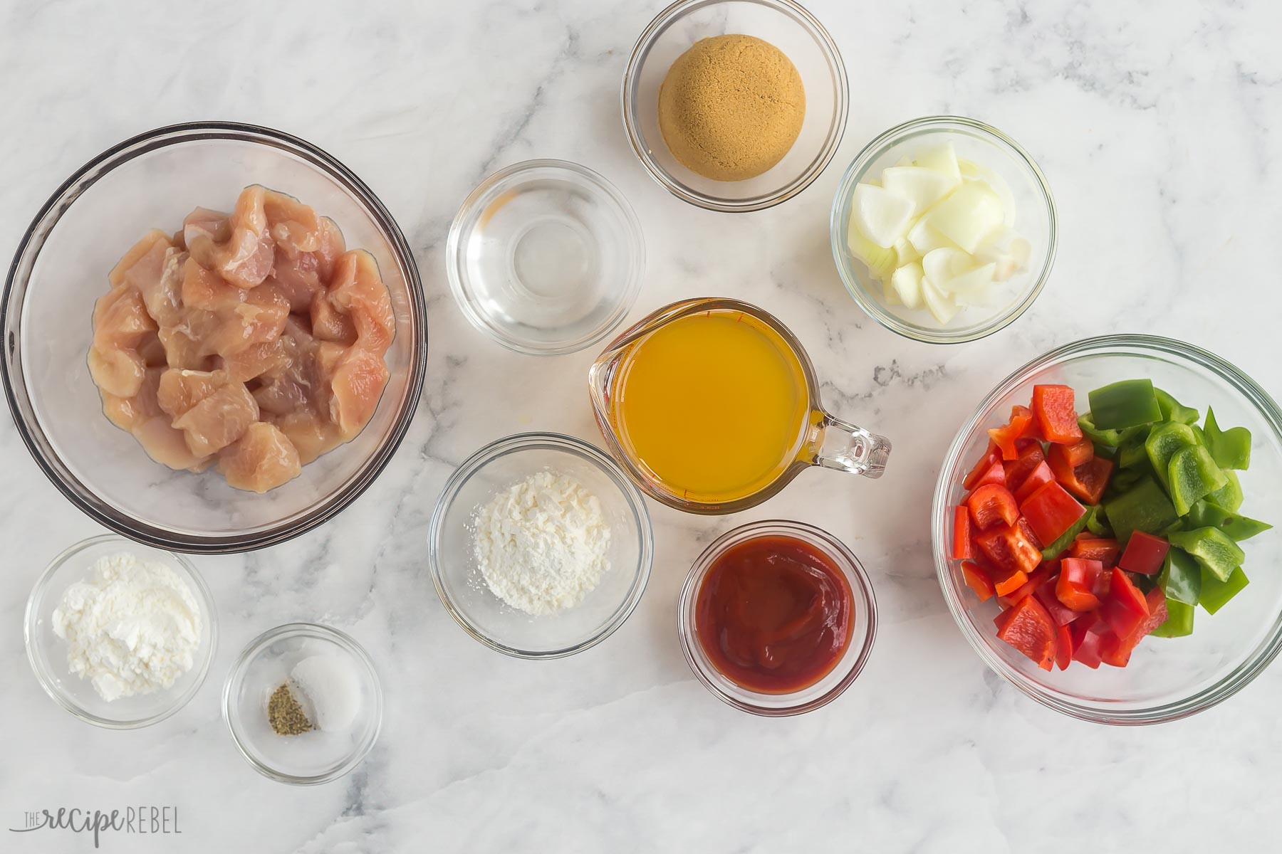 ingredients for sweet and sour chicken laid out on white background