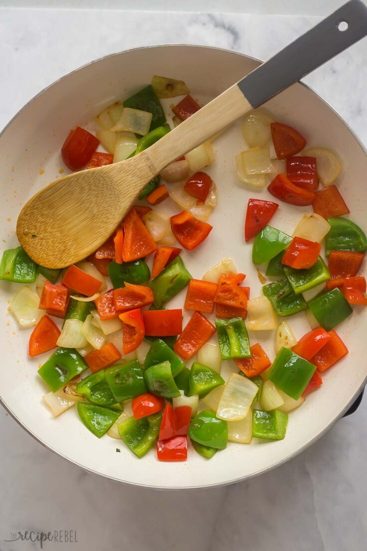red and green peppers cooking in a pan