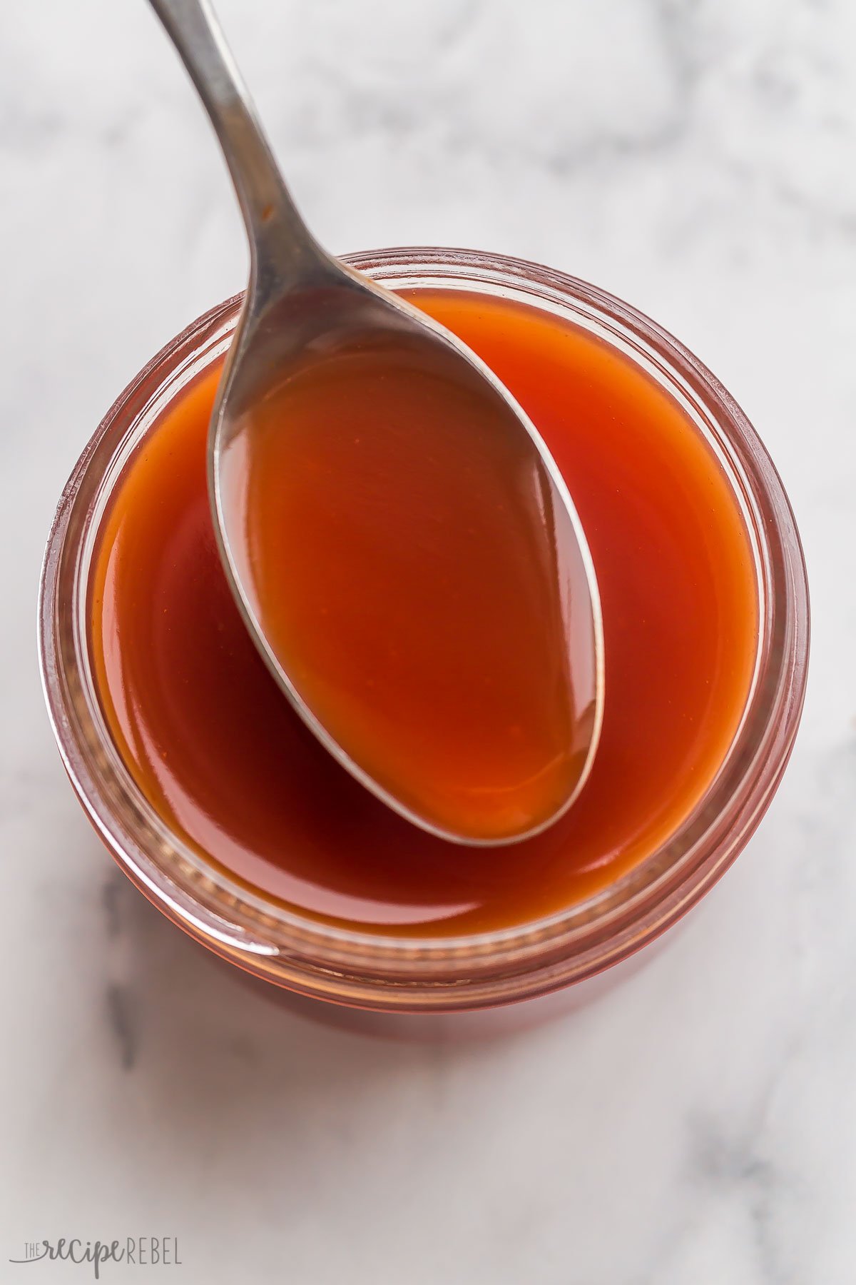 overhead image of sweet and sour sauce in small jar with spoon