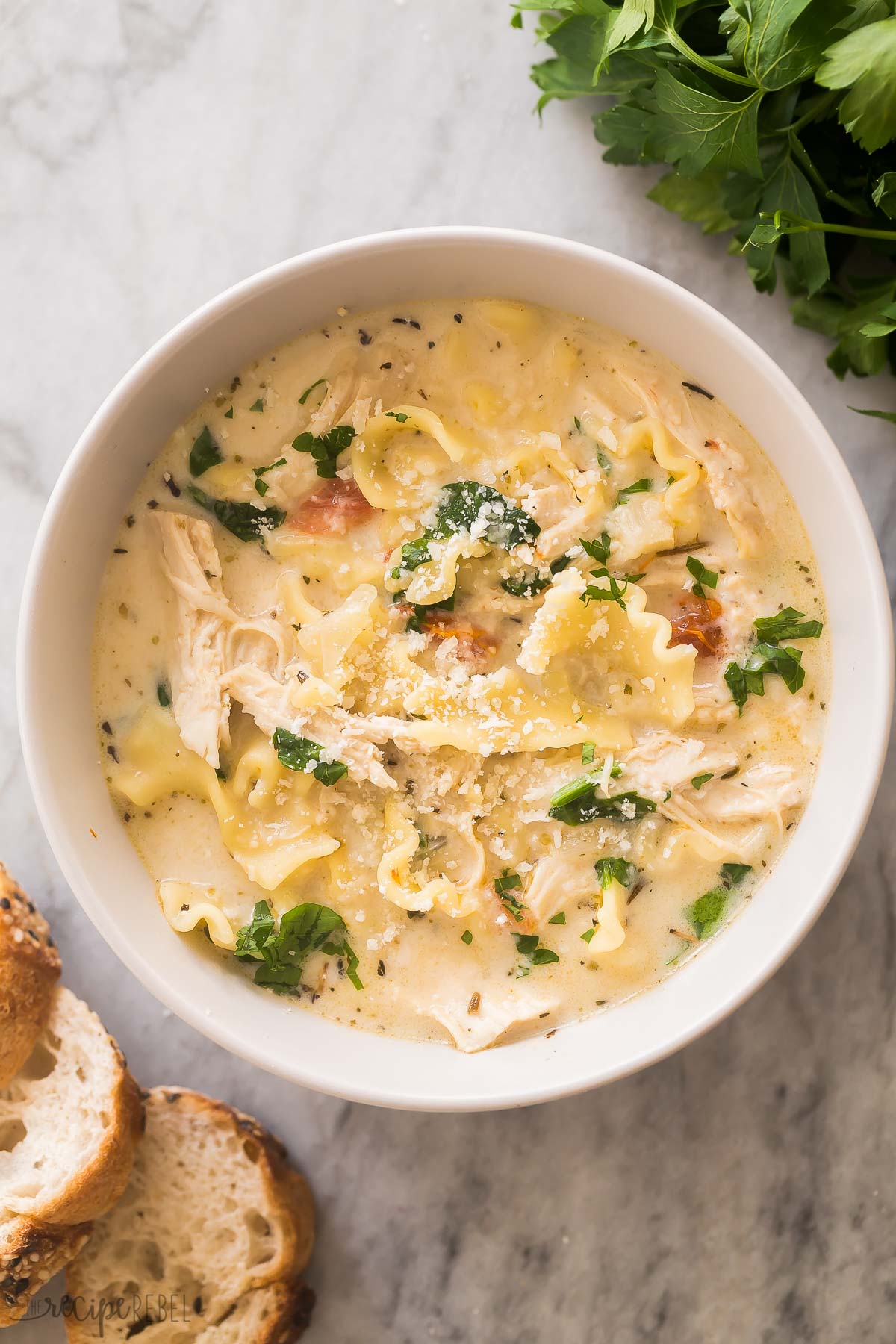 This White Lasagna Soup is your favorite pasta bake in soup form! It's rich, creamy, and packed with tender chicken, veggies, and cheese! #soup #recipe #dinner | soup recipes | easy dinner ideas | chicken breast | shredded chicken | comfort food close up overhead image of white lasagna soup