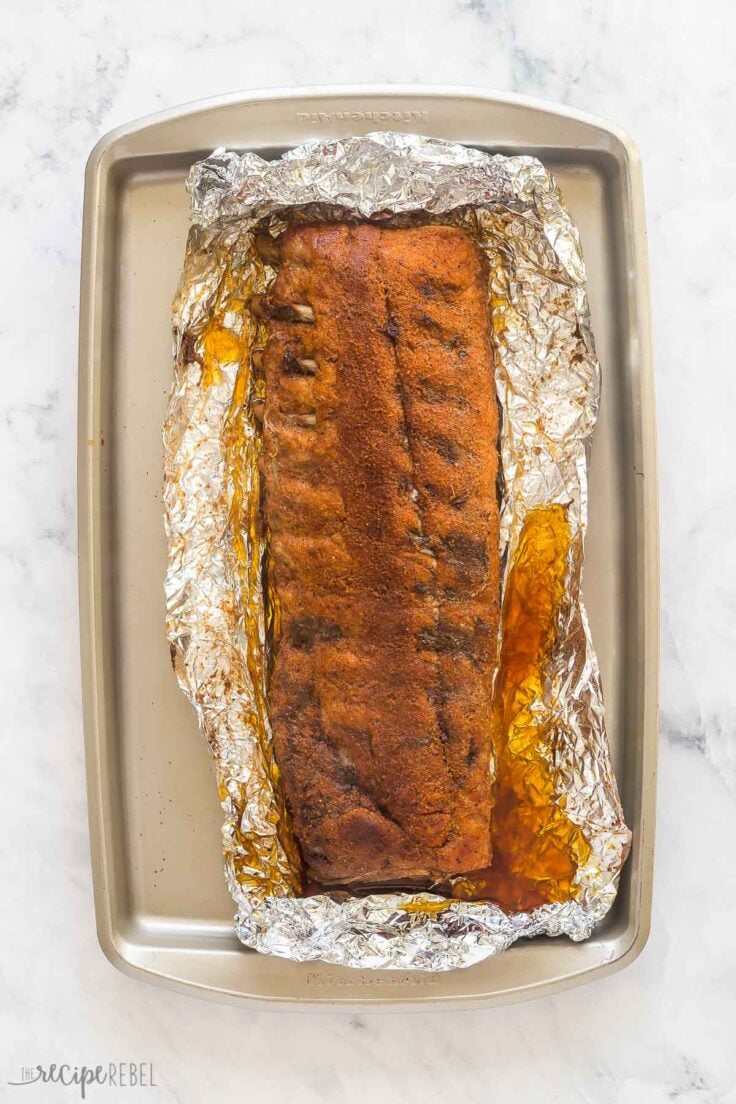 baked ribs unwrapped on foil ready for barbecue sauce