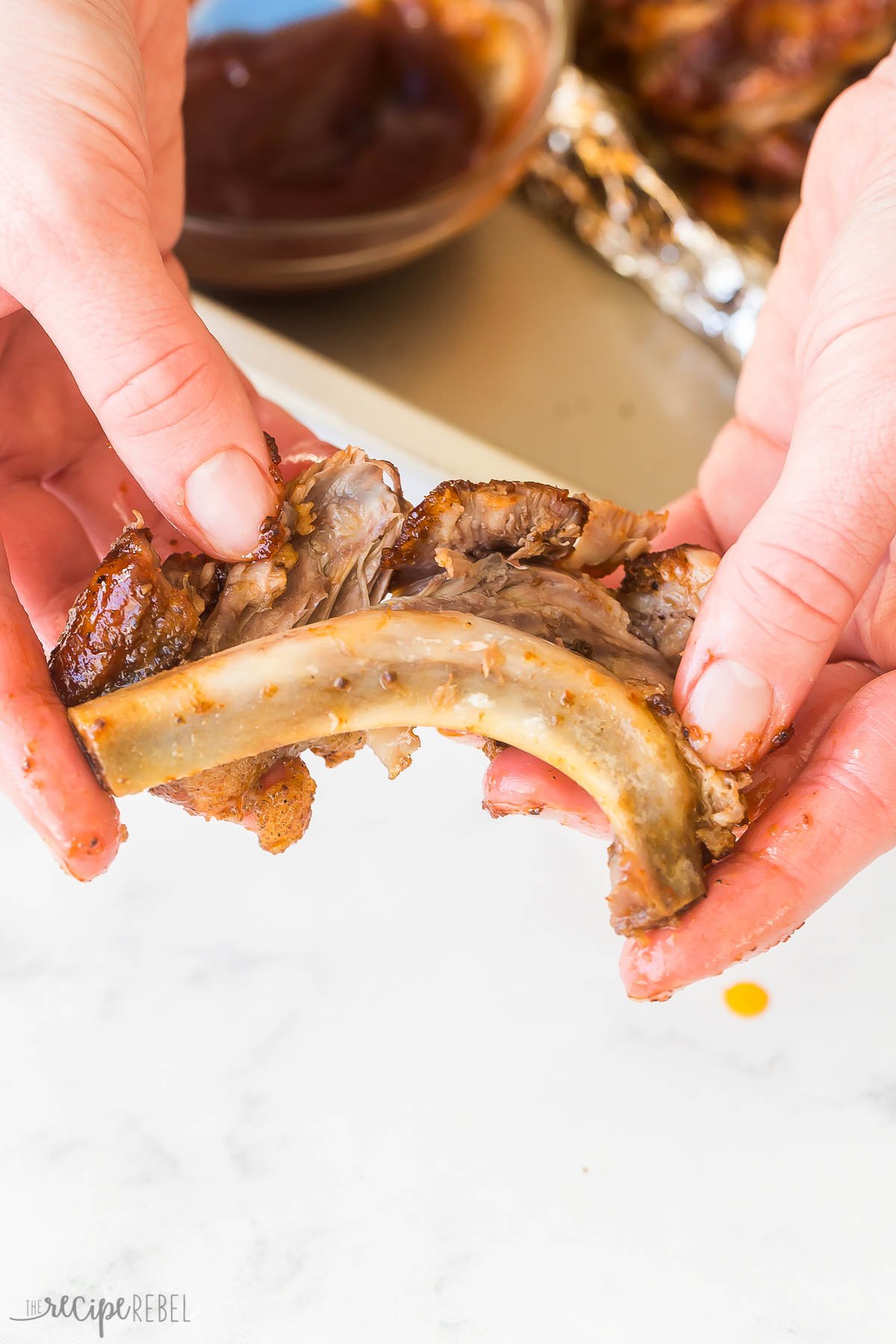 hands pulling rib meat off the bone