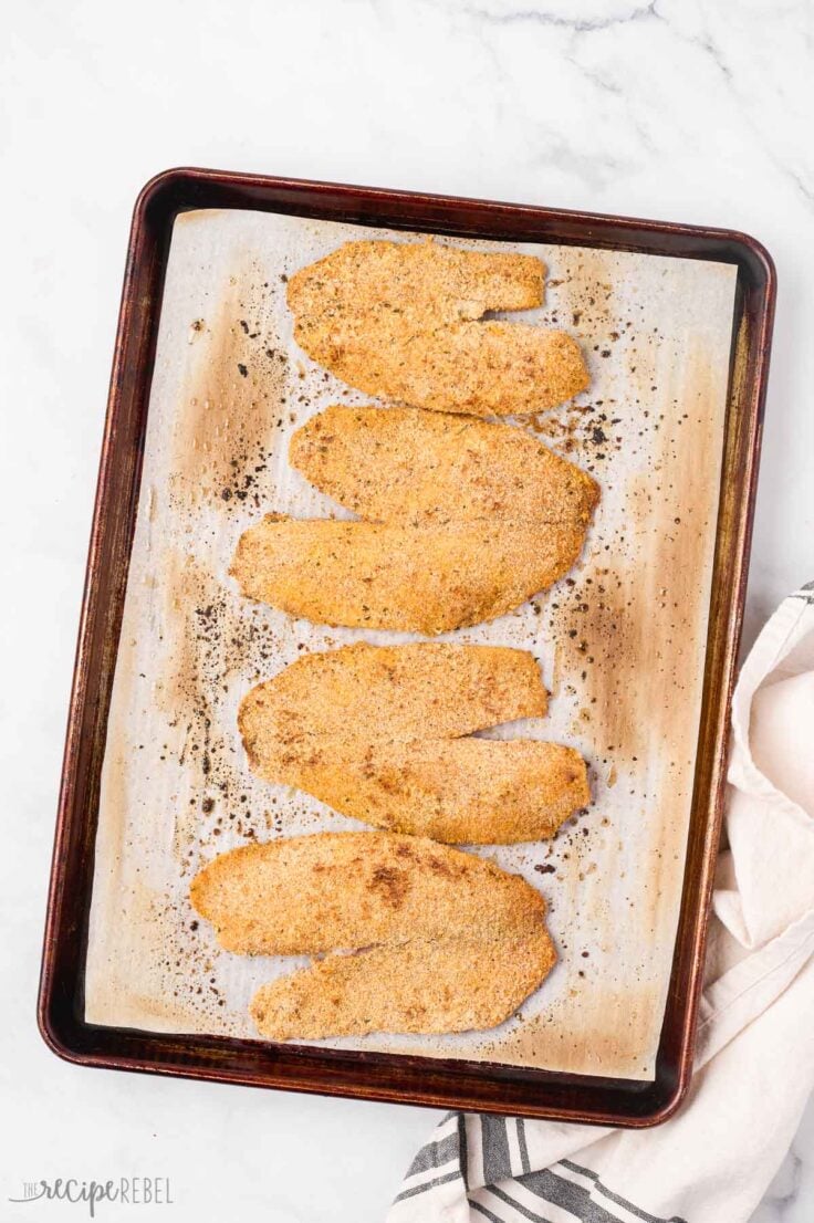 finished baked tilapia on baking sheet lined with parchment