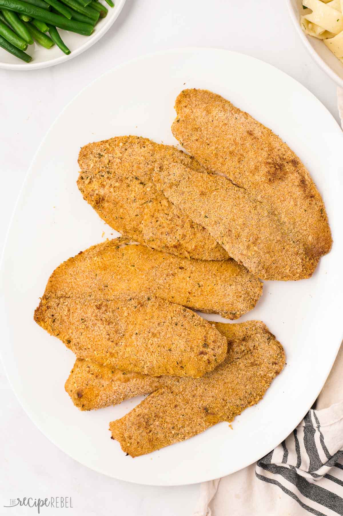 overhead image of four tilapia filets on a white plate