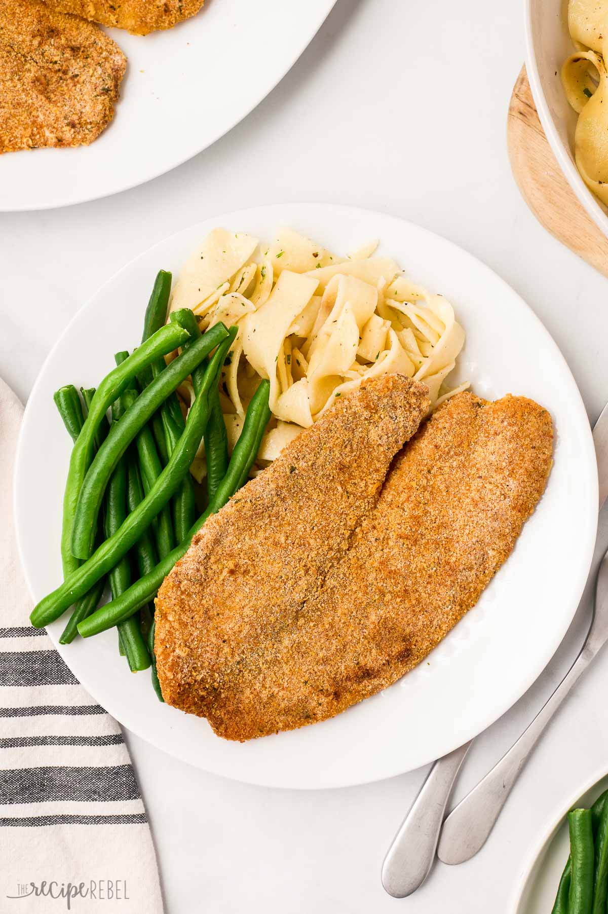 overhead image of baked tilapia with green beans and noodles