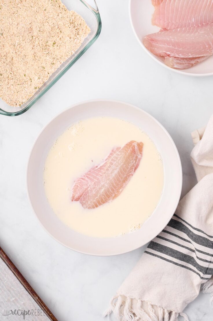 tilapia filets being soaked in buttermilk