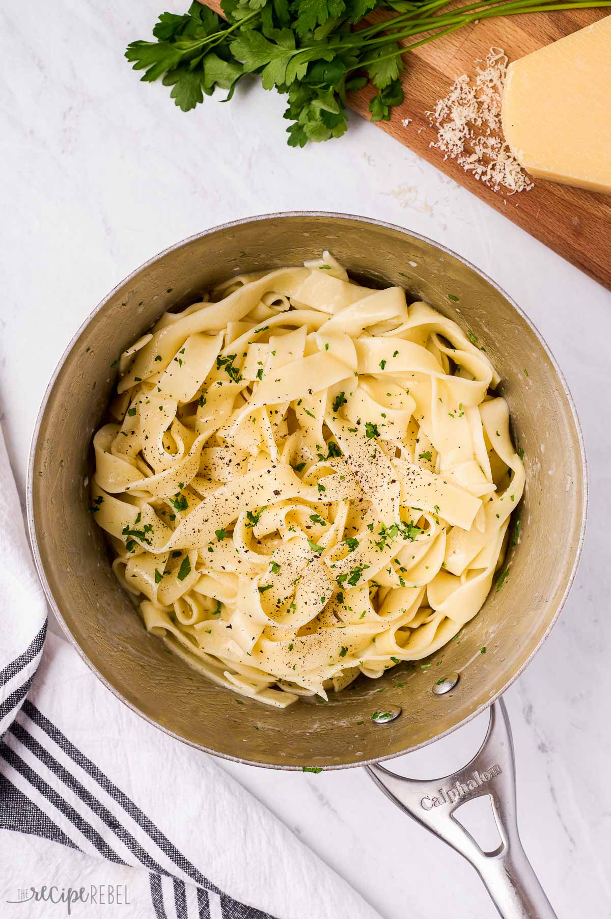 overhead image of buttered pappardelle in pot with parmesan