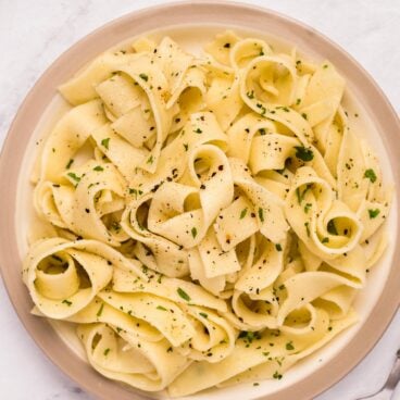 overhead image of plate of buttered noodles with parsley