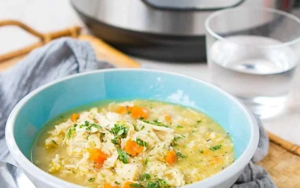 A soup bowl filled with chicken and rice soup.