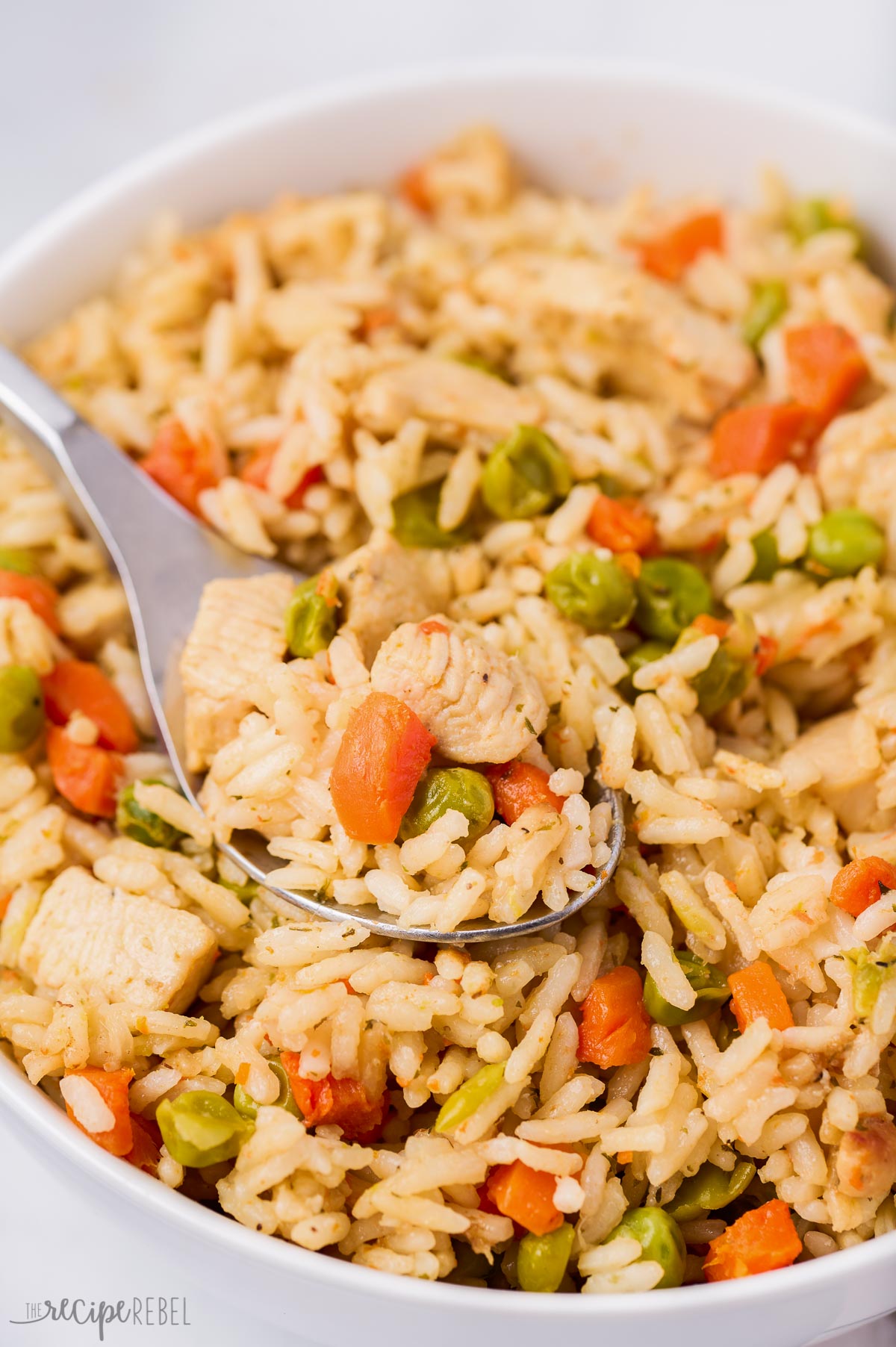 close up image of instant pot chicken and rice in bowl with spoon
