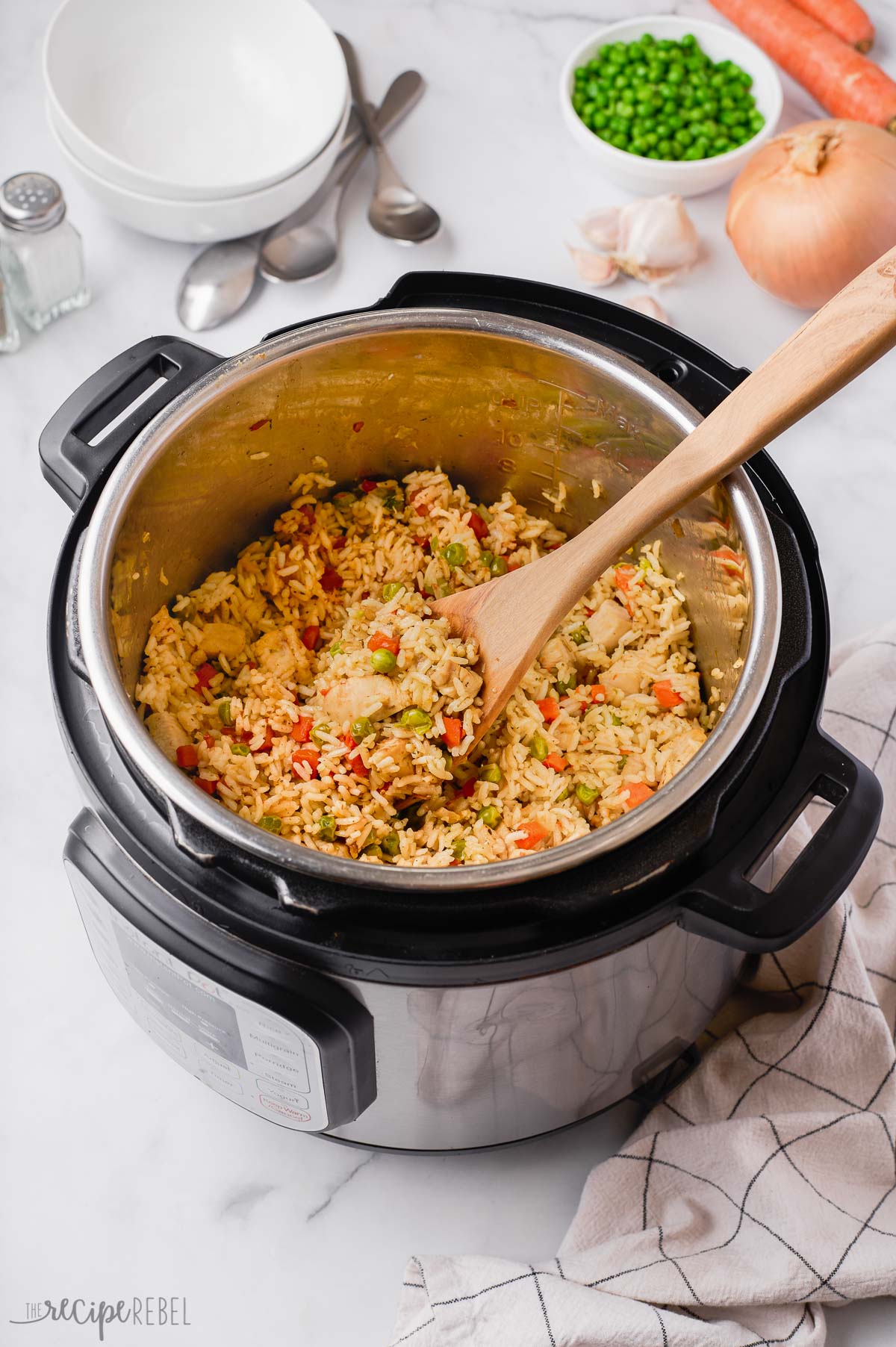chicken and rice in instant pot with wooden spoon stuck in