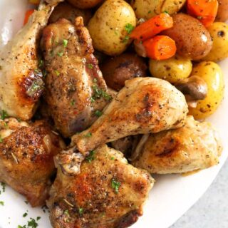 Chicken drumsticks served next to vegetables.