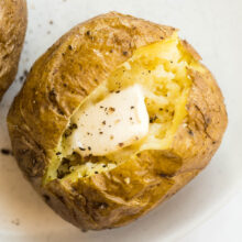 close up image of baked potato made in the microwave with butter