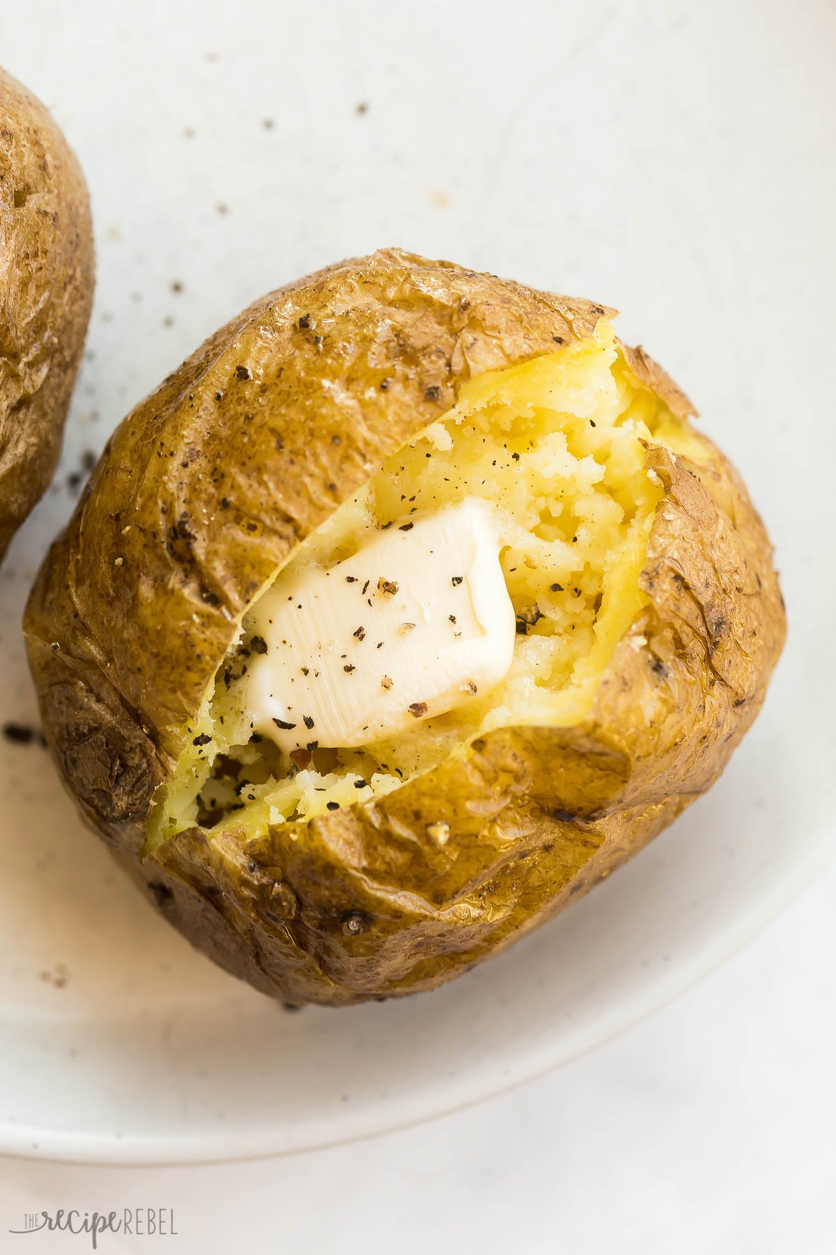 close up image of baked potato made in the microwave with butter