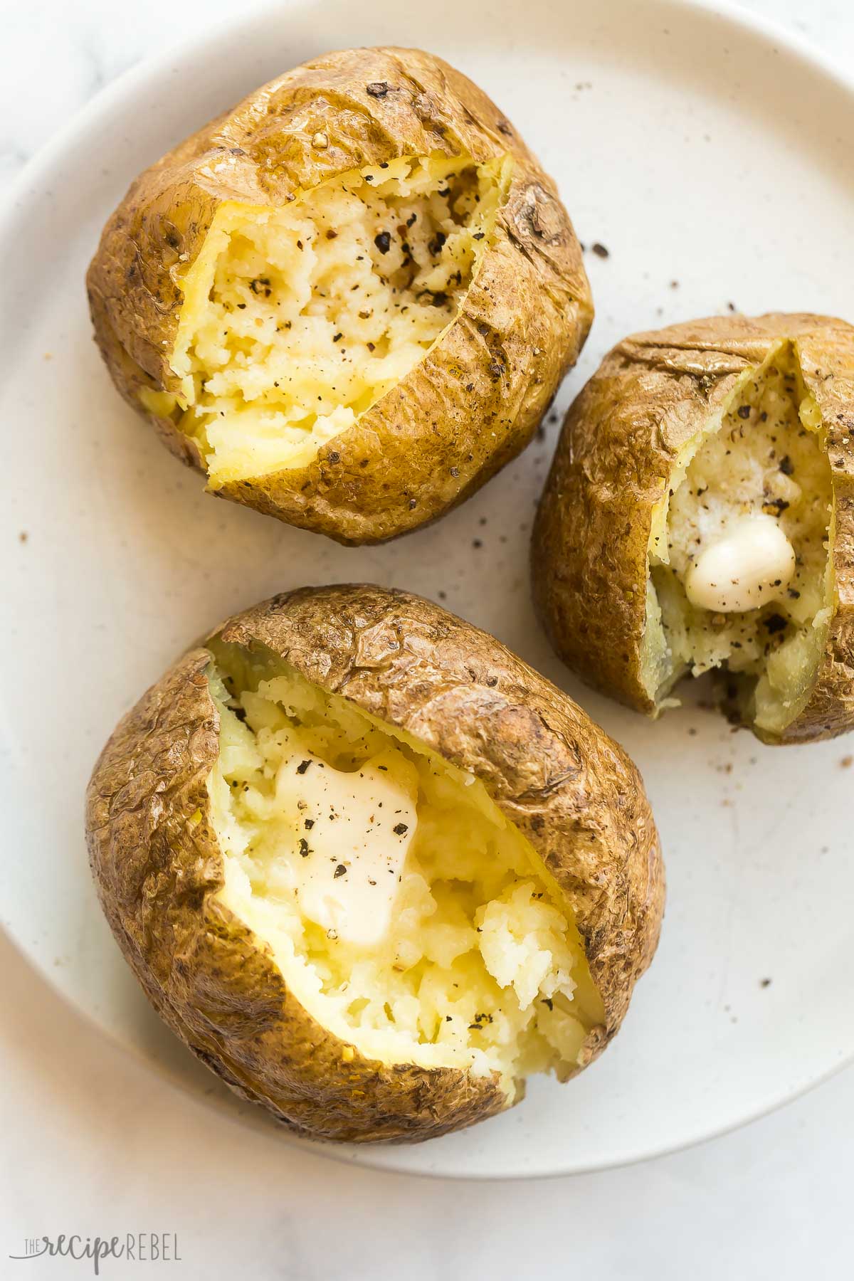 plate of microwave baked potatoes with butter salt and pepper