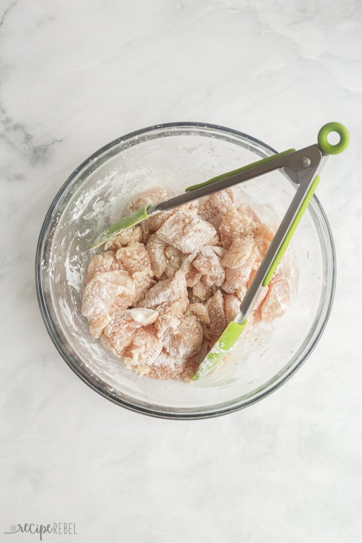 chicken pieces coated in corn starch in glass bowl