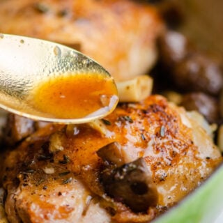 Gravy is spooned over top baked chicken with mushrooms.