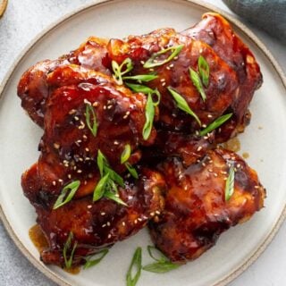 A pile of teriyaki chicken on a plate.