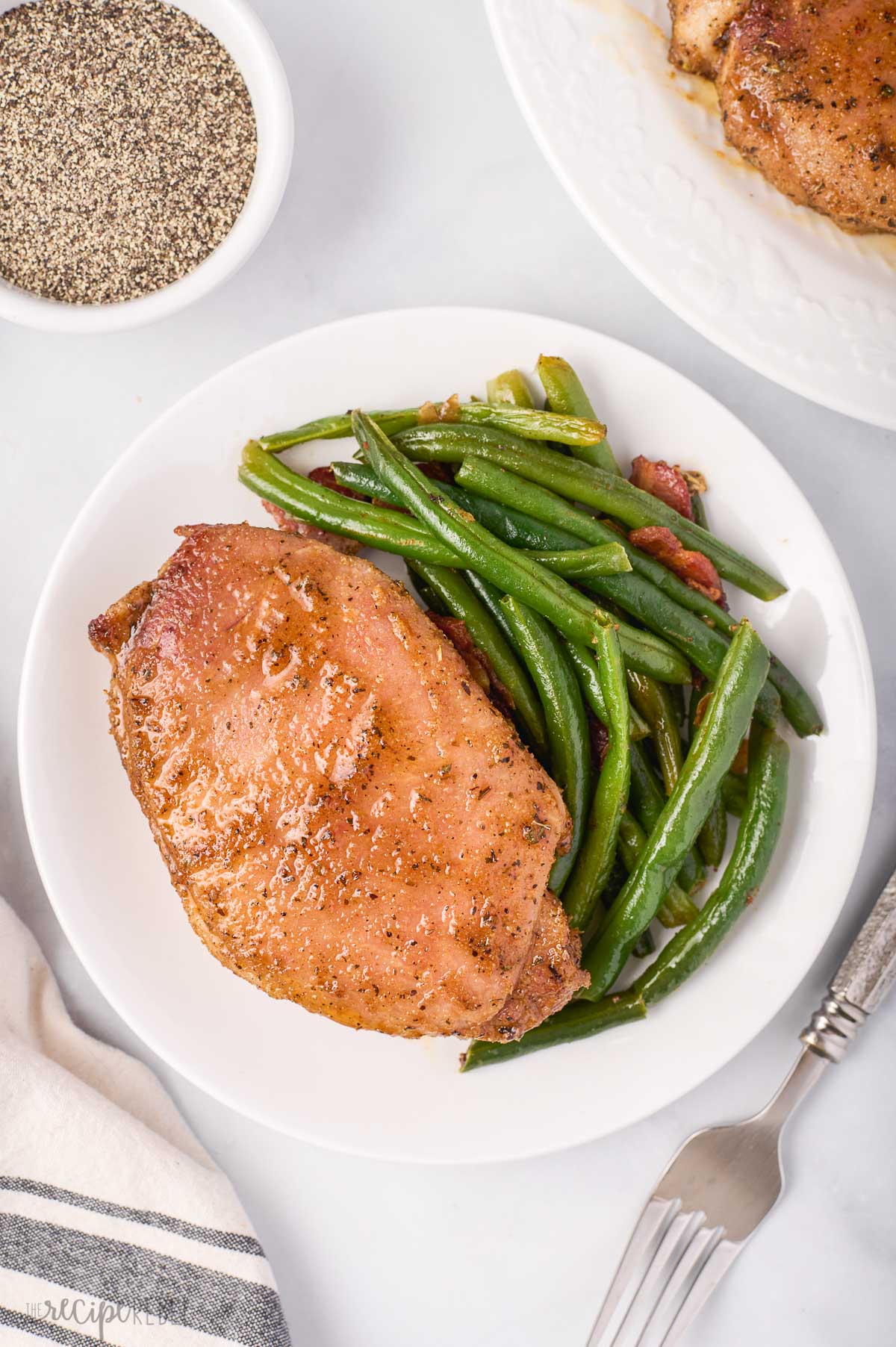 overhead image of baked pork chops with green beans on the side