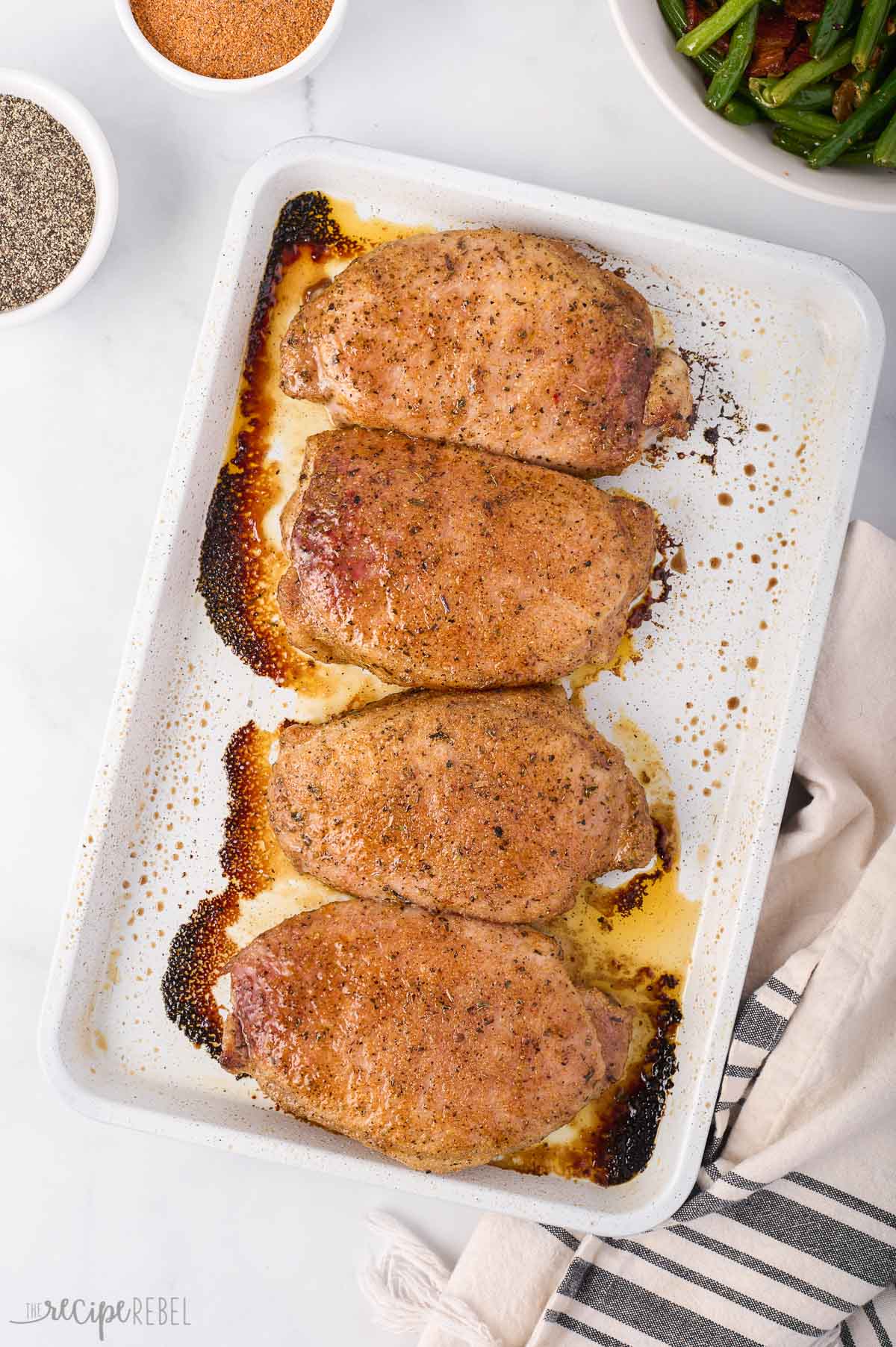 overhead image of baked pork chops on sheet pan