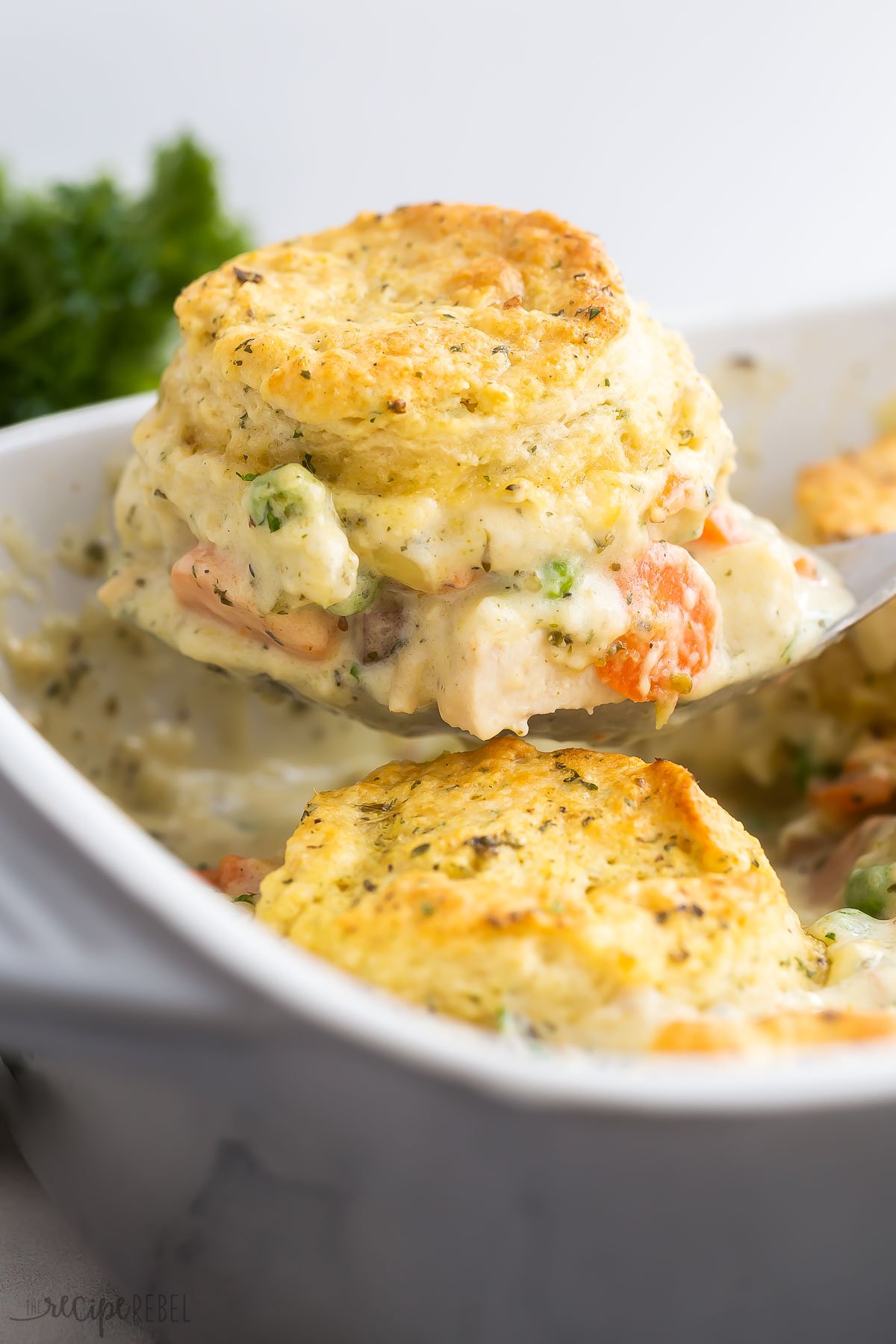 ladle scooping chicken pot pie casserole with biscuits
