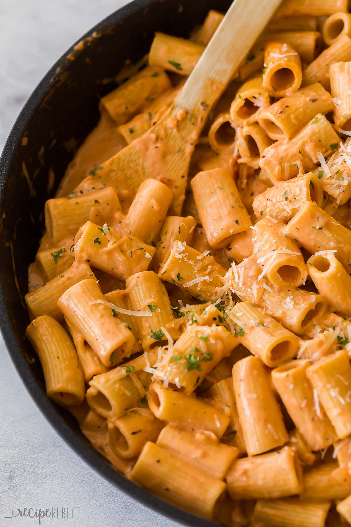 close up image of creamy tomato rigatoni pasta in skillet