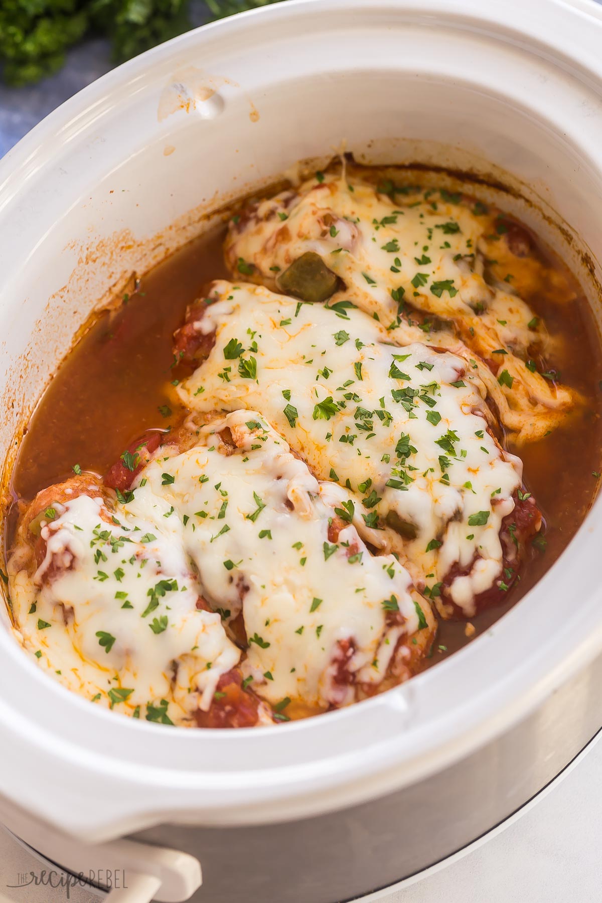 close up image of salsa chicken in crockpot with mozzarella