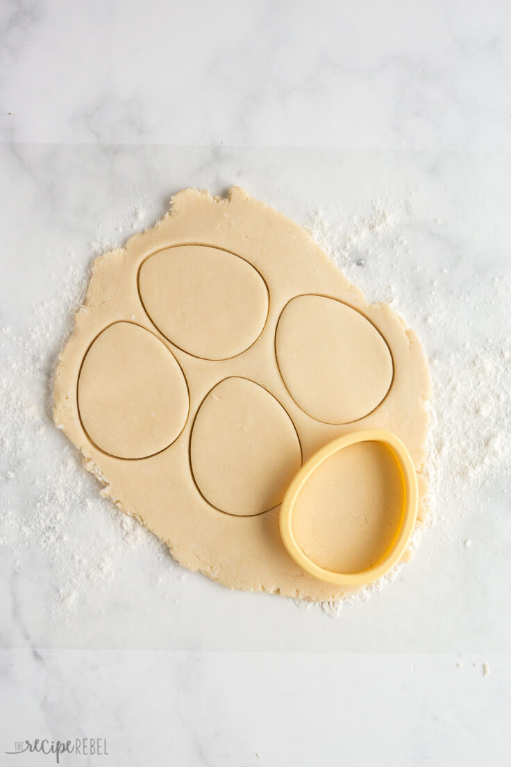 using an easter egg cookie cutter to cut out cookies