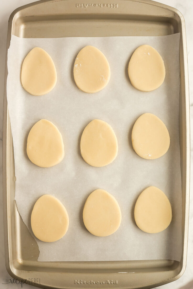 easter egg shaped cookies on a parchment lined sheet pan