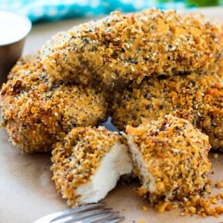 Everything bagel chicken breasts piled on a plate.