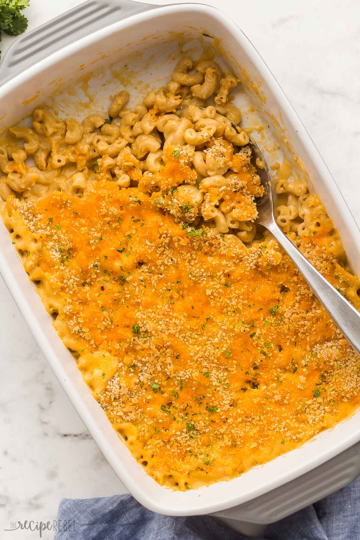 This Healthier Baked Mac and Cheese is a lightened-up version of a comfort food classic. It's rich, creamy, cheesy, and topped off with crispy, golden-brown breadcrumbs. #macaroni #dinner #recipes | easy dinner ideas | easy recipes | pasta recipe | macaroni and cheese overhead image of baked mac and cheese with metal spoon stuck in