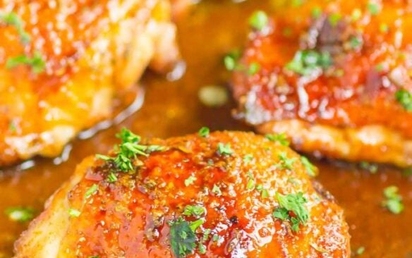 Close up of honey balsamic chicken thighs in a baking dish.