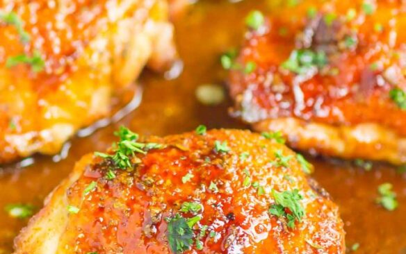 Close up of honey balsamic chicken thighs in a baking dish.