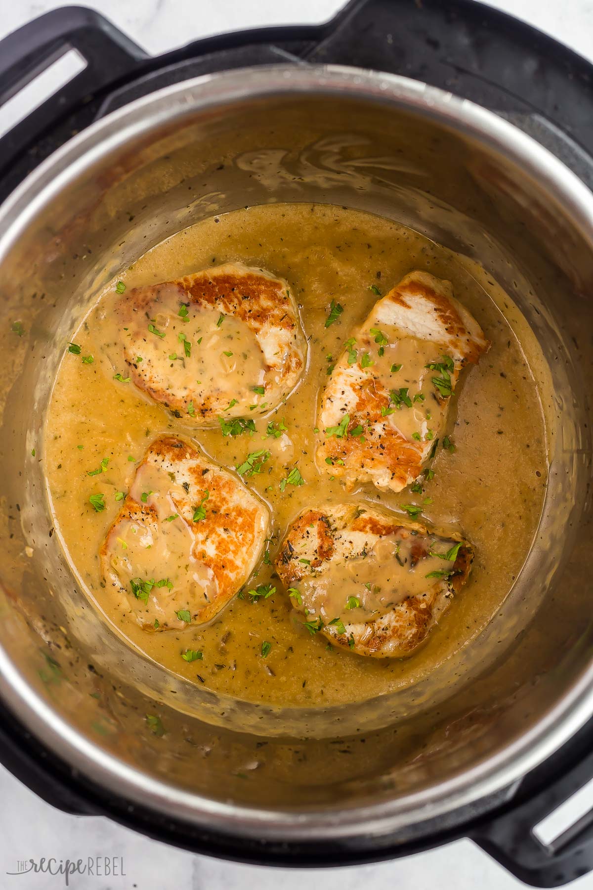 overhead image of pork chops in instant pot with gravy