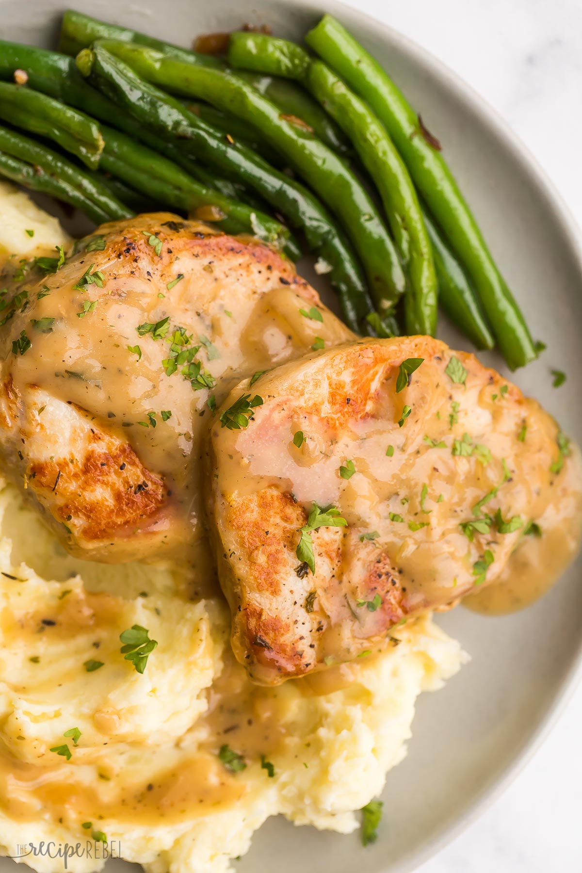 close up image of instant pot pork chops with gravy and green beans