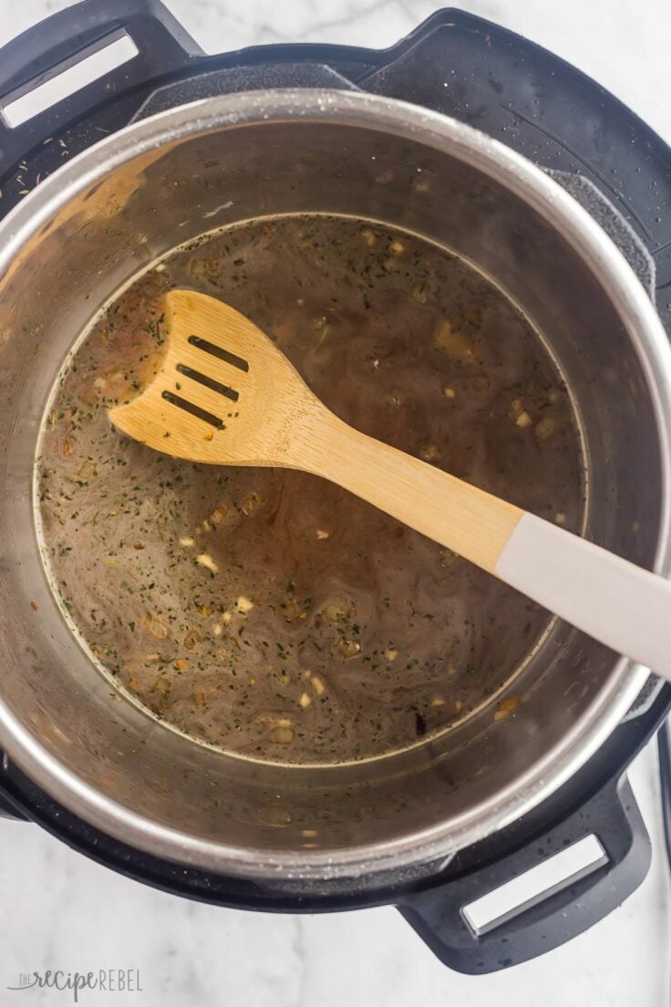 deglazing the instant pot with broth and wooden spoon